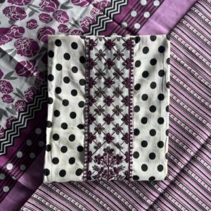 Unstitched Mal Mal cotton suit set with black polka dots, purple floral embroidery, and matching printed fabrics, laid out on a table