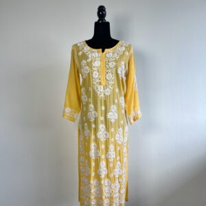 Black half-body mannequin displaying a yellow chikankari kurti with intricate white embroidery, three-quarter sleeves, and a flowing design.
