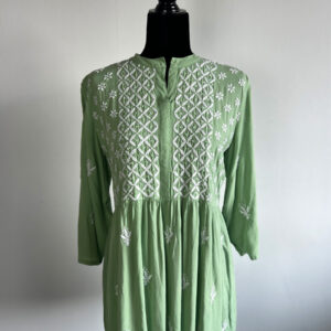 Green short kurti with white floral embroidery, displayed on a black mannequin.