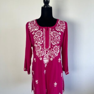 Magenta short kurti with intricate white floral embroidery, displayed on a black mannequin