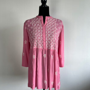 Pink embroidered kurti with intricate white floral patterns, displayed on a black mannequin against a plain background
