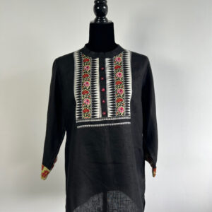 Black linen kurti on a mannequin with embroidered panel, red buttons, and contrast cuffs.