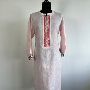Pink linen kurti on a mannequin, featuring a white front panel with embroidered detailing and floral-printed cuffs.