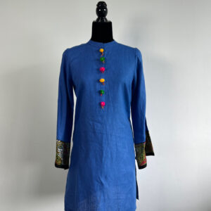 Blue linen kurti on a black half-body mannequin, featuring colorful fish buttons and printed cuffs.