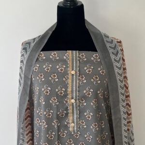 Grey unstitched salwar material displayed on a mannequin, featuring small floral prints with beige and brown detailing. Paired with a chevron-printed dupatta in grey, white, and rust brown tones.