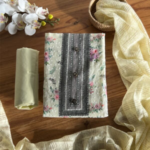 Folded ivory floral top with black placket and buttons, yellow pant rolled beside it, dupatta styled around