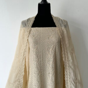 Unstitched 3-piece material set in soft beige displayed on a black mannequin, featuring delicate embroidery on the top, paired with a nude-toned dupatta and plain matching pant material.