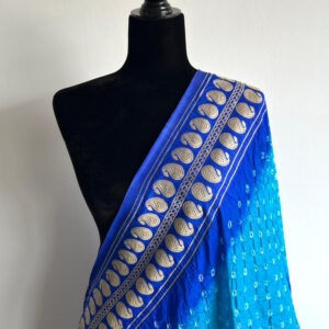 Mannequin draped in a blue ombré dupatta with golden floral paisley embroidery and bandhani detailing