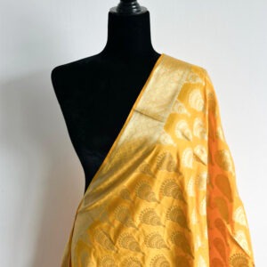Mustard dupatta with traditional woven motifs and zari border, displayed on a black mannequin with close-up shots of tassels and fabric details.
