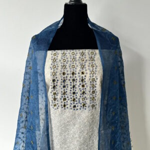 White unstitched 3-piece set on a black mannequin, with floral embroidery and mirror detailing on the top, paired with a sheer dual-tone dupatta.