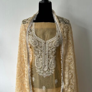 Mannequin displaying a soft sand-colored unstitched top with intricate white thread embroidery, styled with a matching embroidered dupatta draped over the shoulders. Fabric is semi-sheer and lightweight, showcasing detailed floral and paisley motifs.