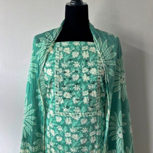 Green unstitched 3-piece material set displayed on a mannequin, featuring a floral-embroidered top, matching leafy dupatta, and wavy pant fabric