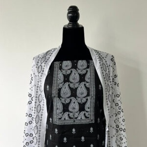 Black unstitched material set with white printed dupatta displayed on mannequin.