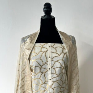 Ivory unstitched 3-piece material set displayed on mannequin showing gold thread neckline and matching sheer gold-detailed dupatta.